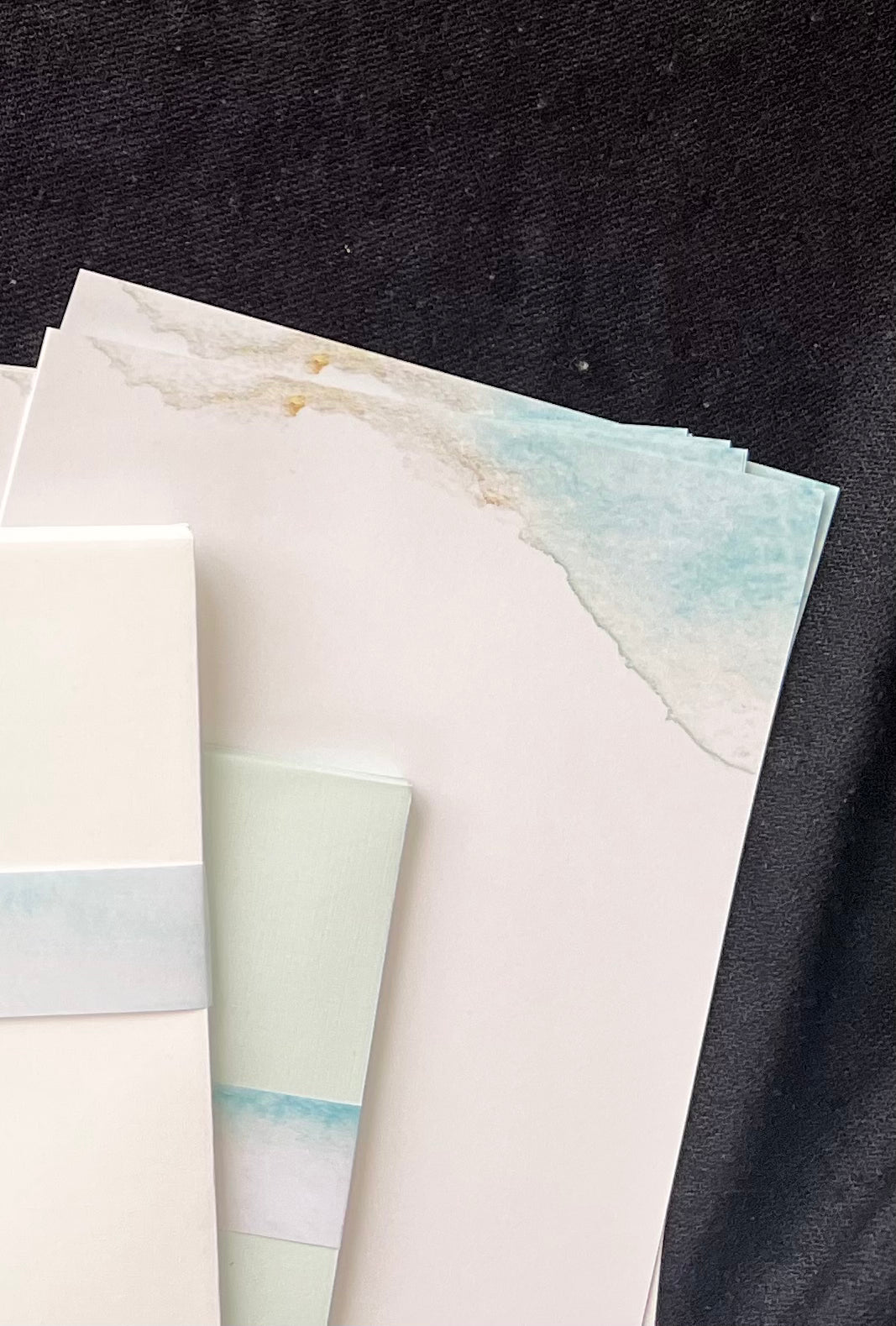 Close-up of water and beach painting on corner of letter sheets