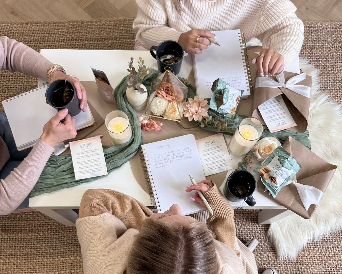 3 friends sitting together for a journaling experience at a nicely decorated table